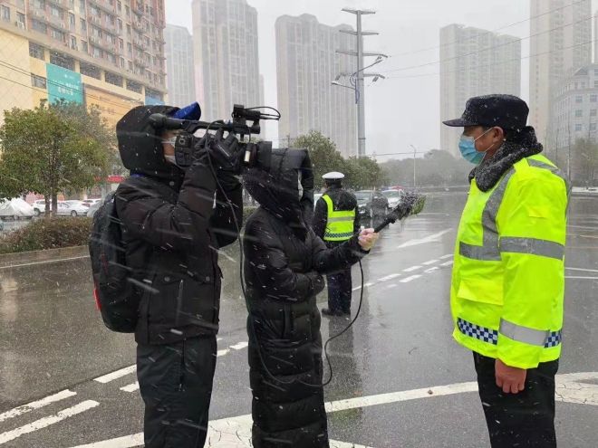 孝感市融媒體中心楊亞玲（風(fēng)雪中，采訪疫情期間重返一線的退休警察）_副本.jpg.jpg